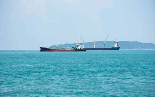 Ship sailing on sea against clear sky