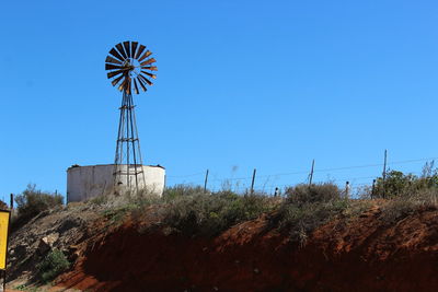 Low angle view of traditional windmill against clear blue sky