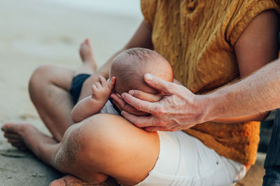 Close-up of parents with baby son at beach