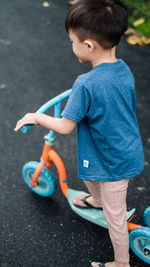 Rear view of boy standing by toy car