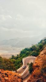 High angle view of road amidst trees against sky