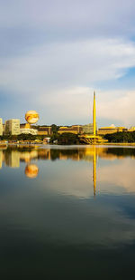 Reflection of built structure in lake against sky