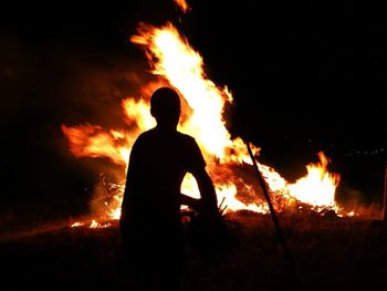 Silhouette man against bonfire at night