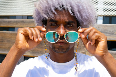 Black man with afro hair putting on sunglasses. sunglasses and afro concept.