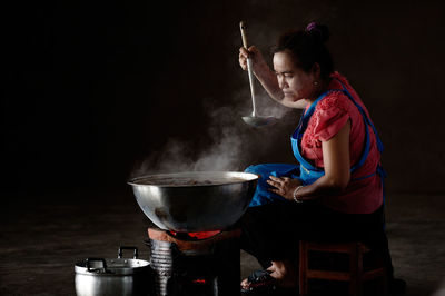 Side view of mature woman preparing food at home