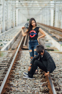 Full length of young woman walking on railroad station platform