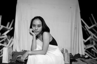 Portrait of young woman sitting on chair