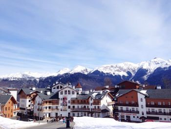 Houses by snowcapped mountains against sky