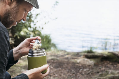 Midsection of man holding drink drinking glass