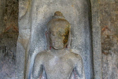 Statue of buddha against wall