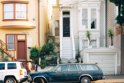 Cars on road by building in city