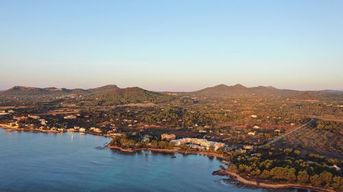 Aerial view of townscape by mountains against clear sky