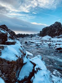 Scenic view of snow covered land against sky