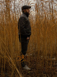 Side view of young man standing on field