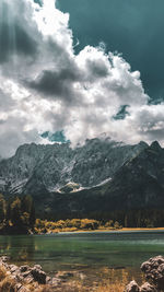 Scenic view of lake by mountains against sky