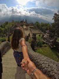 Midsection of woman against trees against sky