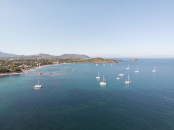 Sailboats in sea against clear sky