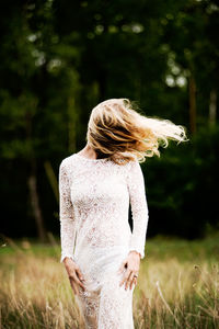 Woman with tousled hair standing on field