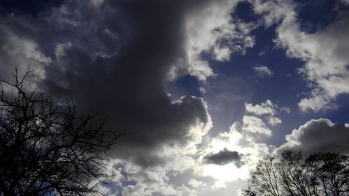 Low angle view of bare tree against cloudy sky