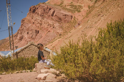 Man standing on rock against mountain