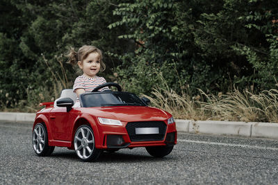 A girl riding a toy car