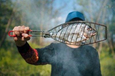 Man holding raw fish for grill