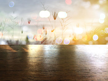 Close-up of wooden table on field during sunset