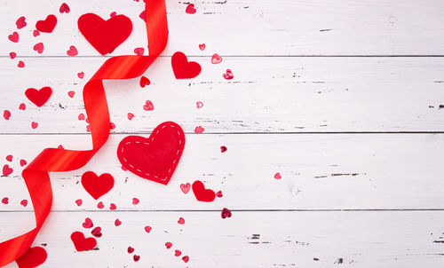 Close-up of red heart shape on white wall