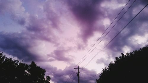 Low angle view of silhouette trees against sky