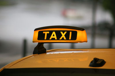 Close-up of yellow sign on car