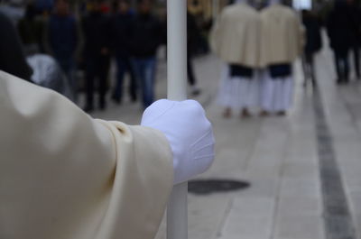 Cropped image of person holding pole on street