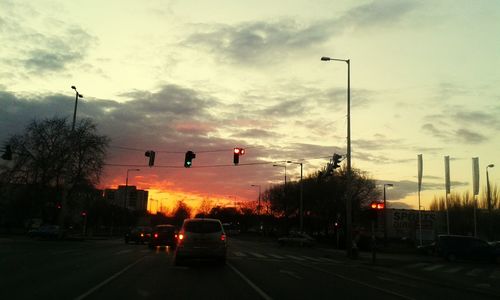 Traffic on road against cloudy sky