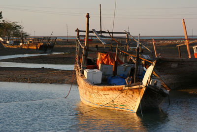 Fishing boats in sea at sunset