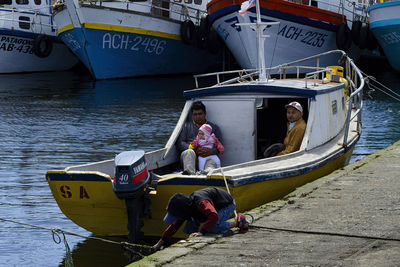 People sitting on boat moored in sea