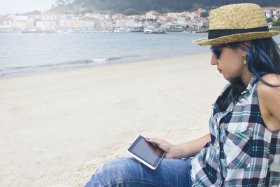 Young woman with tablet on the beach