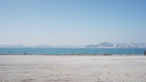 Scenic view of beach against clear blue sky