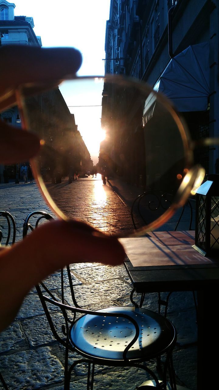 CLOSE-UP OF HAND ON TABLE AGAINST SUNSET