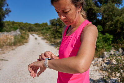 Side view of young man holding sand at beach