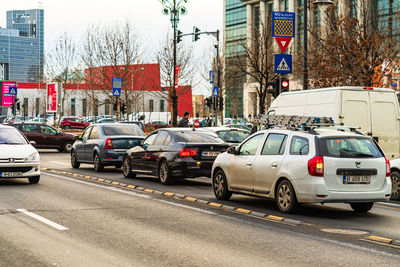 Traffic on road by buildings in city