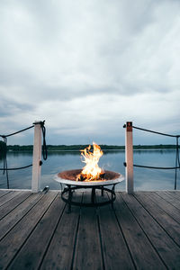 Close-up of bonfire on shore against sky