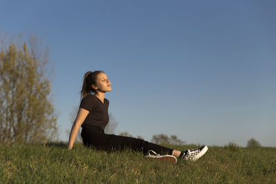 Side view of woman on field against clear sky