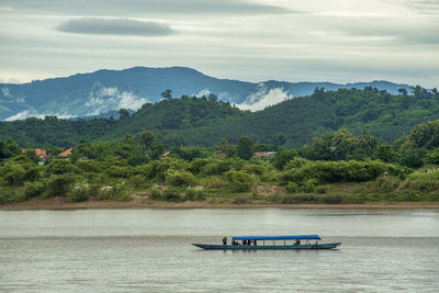 Passenger boat on the mekong river with fog and mountain background