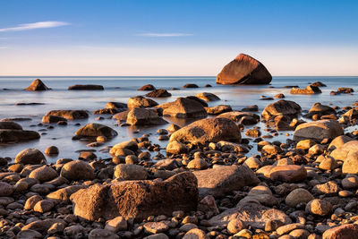 Rocks on sea shore against sky