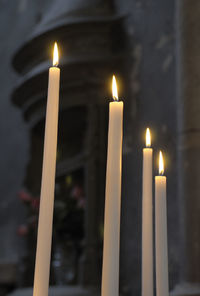 Close-up of lit candles burning in temple