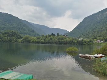 Scenic view of lake by mountains against sky