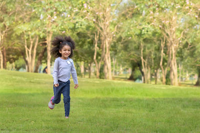 Portrait of happy boy running on grass