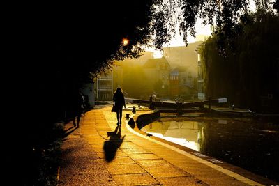 People walking by  canal and lock in city