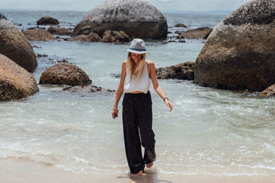Full length of young woman walking at beach