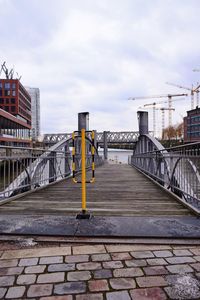 Bridge over river against sky in city