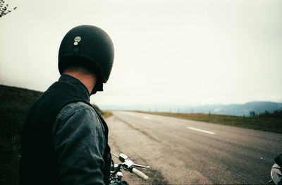 Rear view of man standing on road against sky